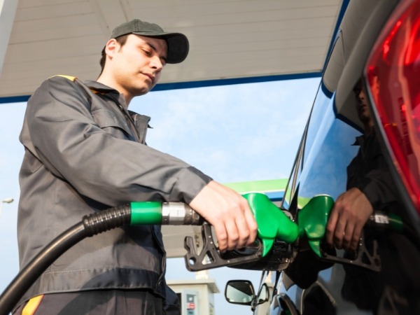 Attendant Fuelling Up a Car