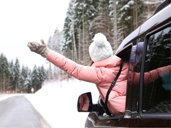 Woman Waving from a Car amid Snow